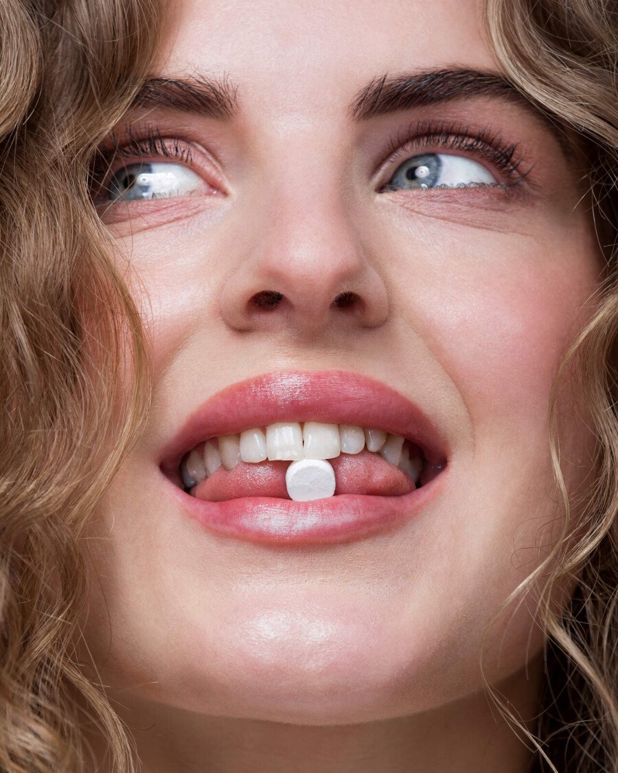 Smiley pasta do mycia zebow w tabletkach kobieta trzymajaca tabletke w ustach 2